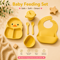 Yellow baby feeding set arranged on a beige background, including a duck-shaped divided plate, bowl, spoon, fork, sippy cup, and bib, with text reading 'Baby Feeding Set' and feature badges below.