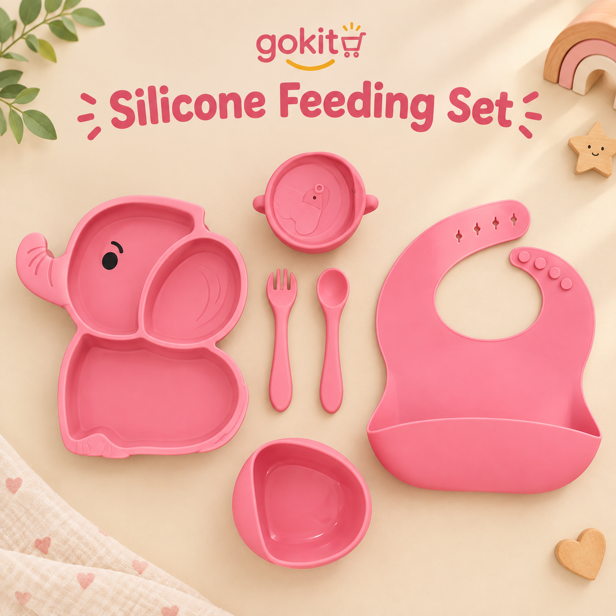 A peachy pink silicone baby feeding set by gokit, including a divided plate, bowl, spoon, fork, bib, and small cup, arranged on a beige background with decorative props and the text 'gokit Silicone Feeding Set'.